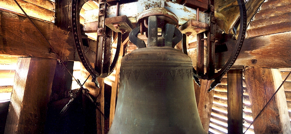 Cette vue permet d'appréhender l'espace du clocher et, en particulier, la charpente de la chaise avec ses contreventements latéraux constitués de câbles et de tendeurs. On comprend aussi mieux le principe de mise en volée avec les deux roues d'entraînement reliées au moteur et à l'inverseur.