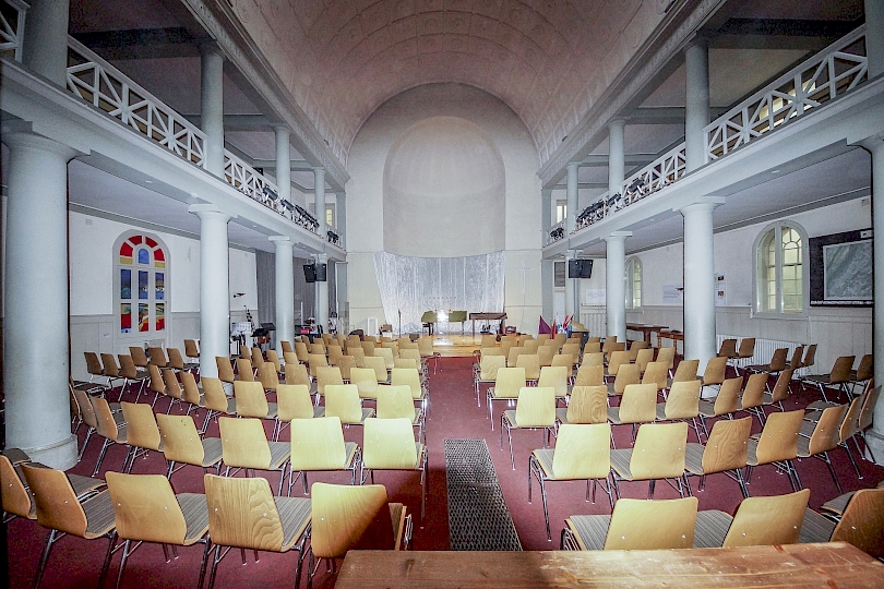 Vue vers le chœur et l’abside hémicyclique en cul de lampe, autrefois équipée de deux baies situées à peu près à l’altitude de la galerie, au- dessus du soubassement en panneau de bois. Photo avant travaux.