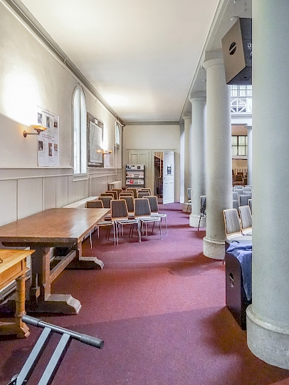 Vue du côté latéral est de la nef central avant travaux. On aperçoit la porte d’accès depuis l’espace de distribution. On remarque que les fenêtres de la façade Est on déjà été équipées de doubles fenêtres intérieures avec du verre isolant.