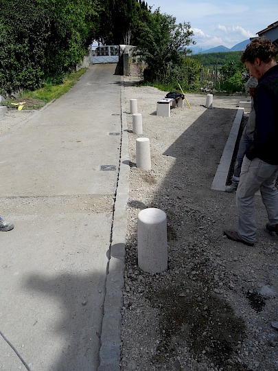 La bordure rehaussée et le caniveau à l'air libre ceinturent la place autour de la fontaine afin de contenir et de drainer les eaux de surface.