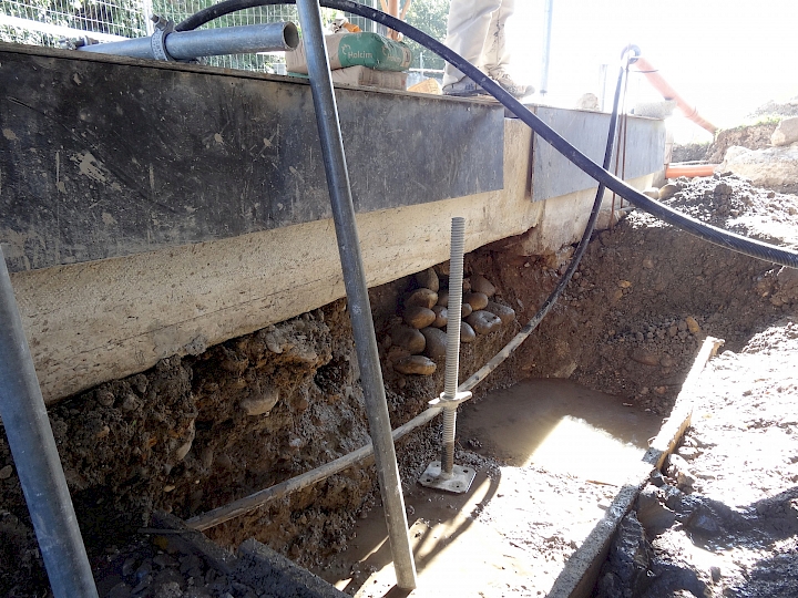 Vue sur l'assise des bassins. Pompage de l'eau en continu et coffrage de la semelle d'assise de la chèvre.