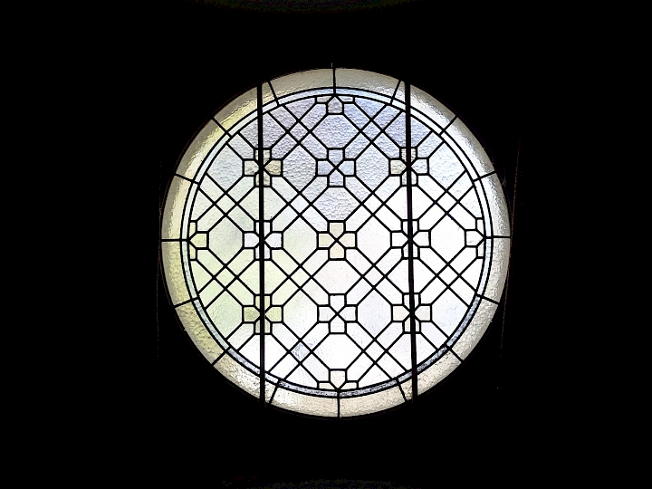 Vitrail assemblé avec des baguettes de plomb au niveau de la nef et de la galerie.