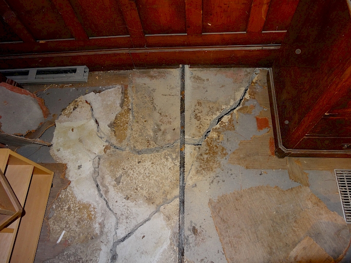 Mise en place des tirants au niveau de la nef, ici au droit du mur de refend. Les deux parties disloquées de la dalle à nervure visible sur cette photo seront retirées et refaites.