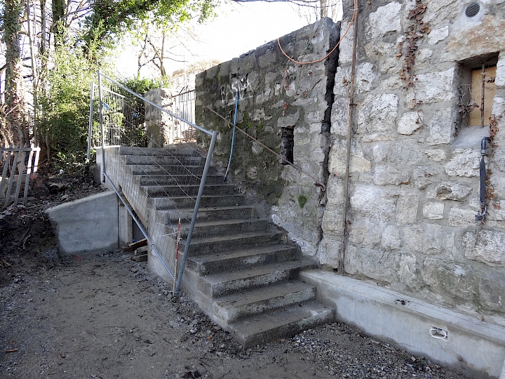 La main courante et le portail ont été conservés, le muret en amont de l'escalier partiellement reconstruit.