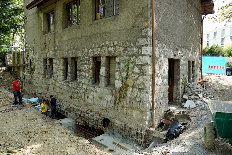Vue générale des travaux de reprise en sous-œuvre, façade nord, côté forêt. 1ère étape; bétonnage des semelles de fondations.