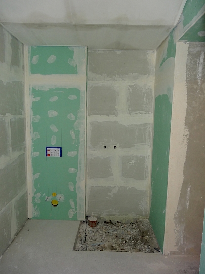 Intégration de doublages hydrophobes et isolants dans l'ancien local technique transformé en local de douche.